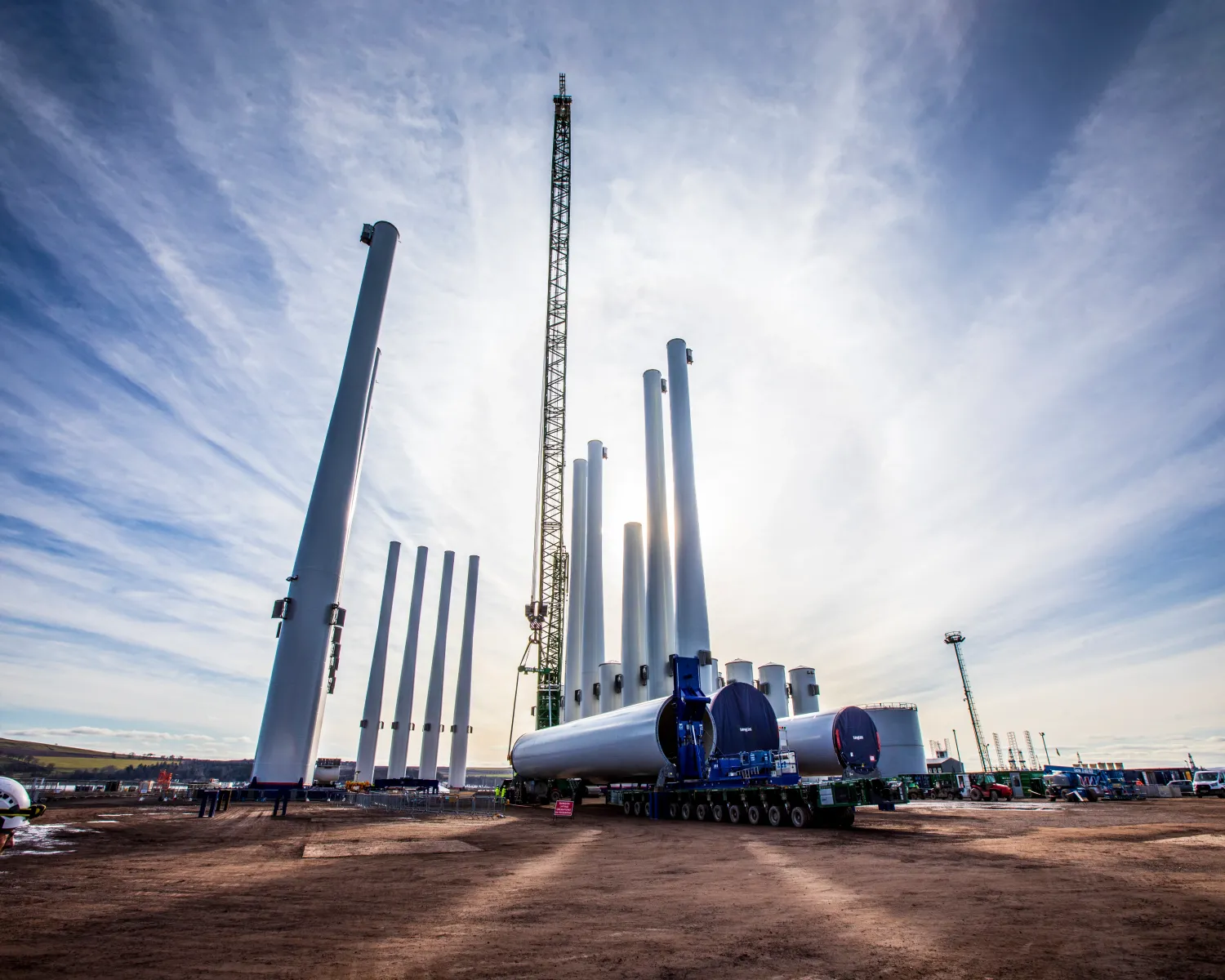 Sun behind wind turbine towers at Port of Nigg